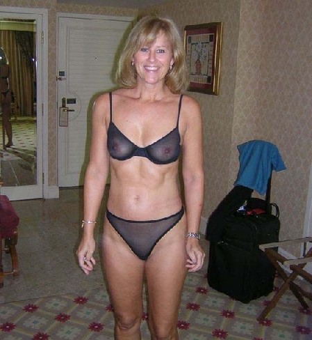 Женщина показывает свое зрелое тело, одевшись в эротический прикид